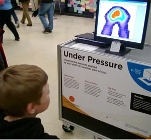 Child sits and watches his body map change on the Tactilus® Sensor System display